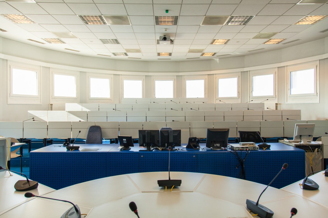 University interpretation classroom with blue curved desk setup and multiple computer stations and microphones.
