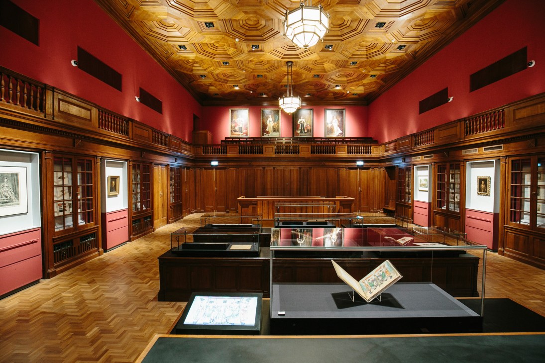 Former courtroom at National Gallery Singapore with red walls, wooden furnishings, and ornate ceiling.