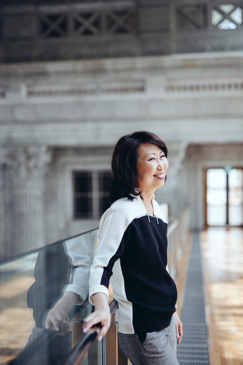 National Gallery Singapore CEO Chong Siak Ching stands in a gallery corridor wearing a white cardigan over a black top.