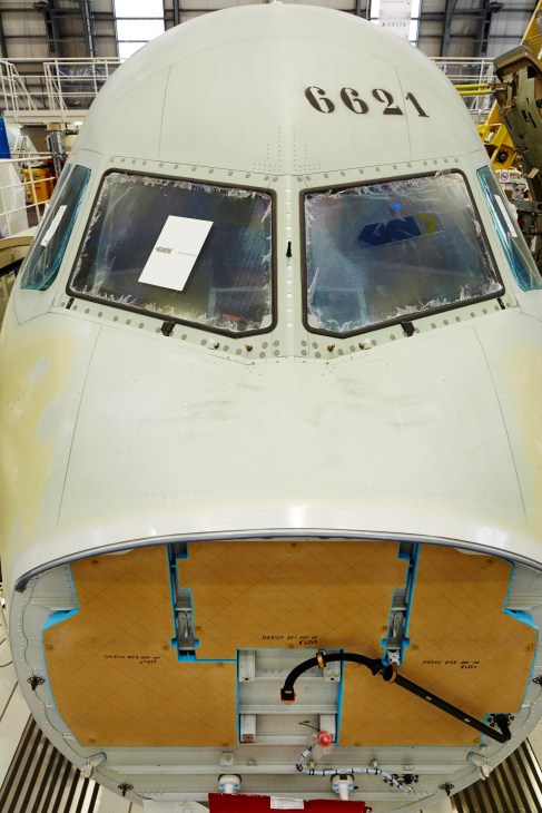 Airbus A320 nose section under assembly with registration 6621 and cockpit windows exposed.