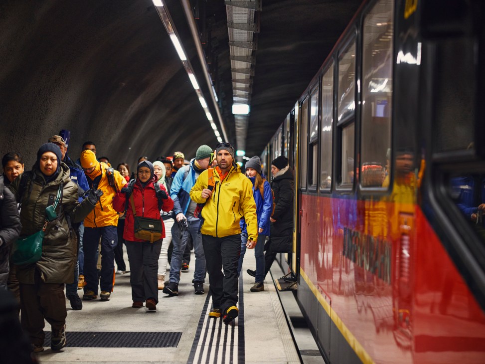 A group of people walking off a train.