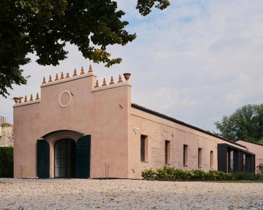 Pink-painted former stable building with decorative roof elements, converted into modern offices and workshop space.