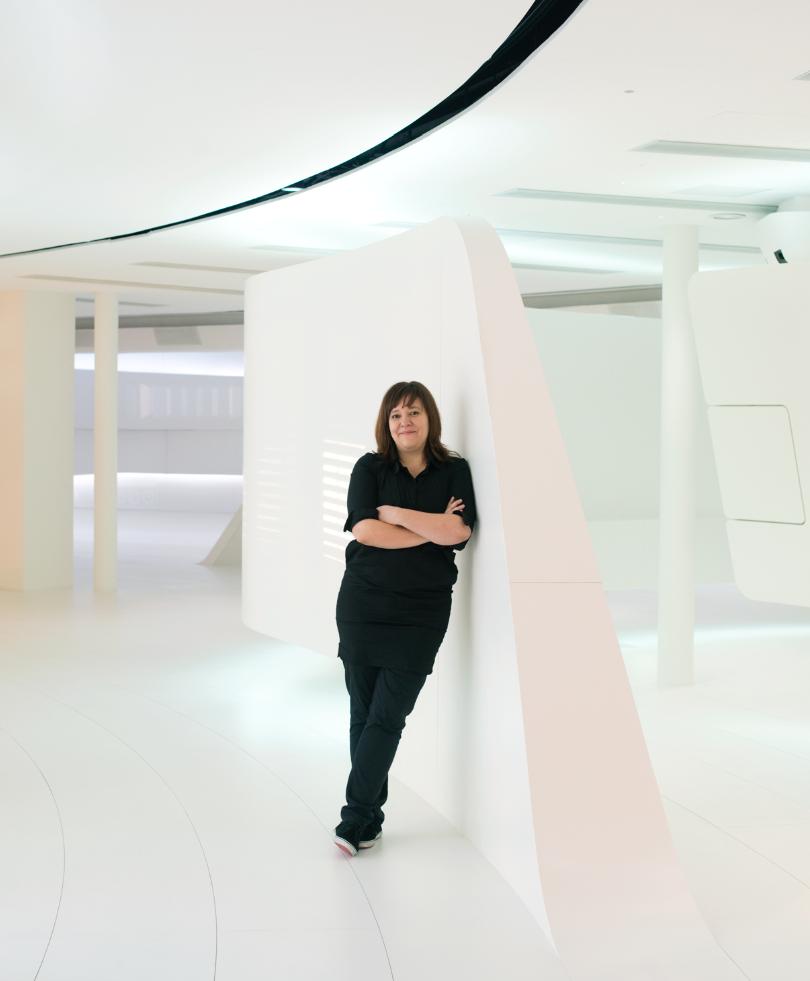 Caroline Seifert, Deutsche Telekom senior vice president, standing in a modern white interior space with curved architectural elements.