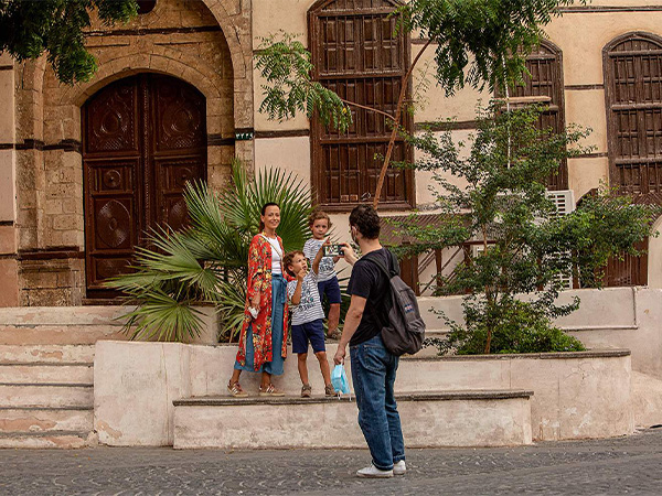 A family posing in front of a building in the old town, in Jeddah.
