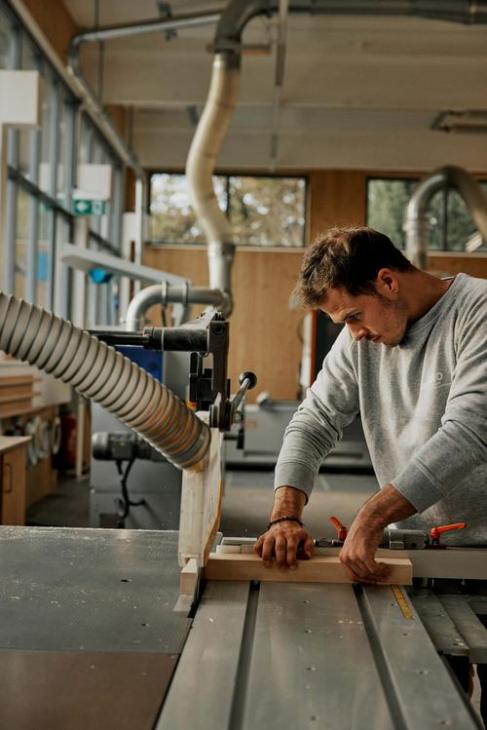 Man cutting wood on handsaw.