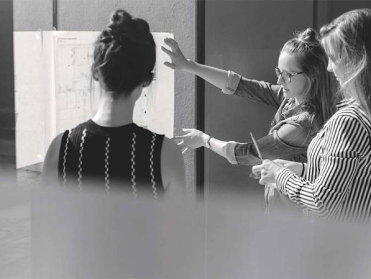 People looking at writings on a whiteboard.