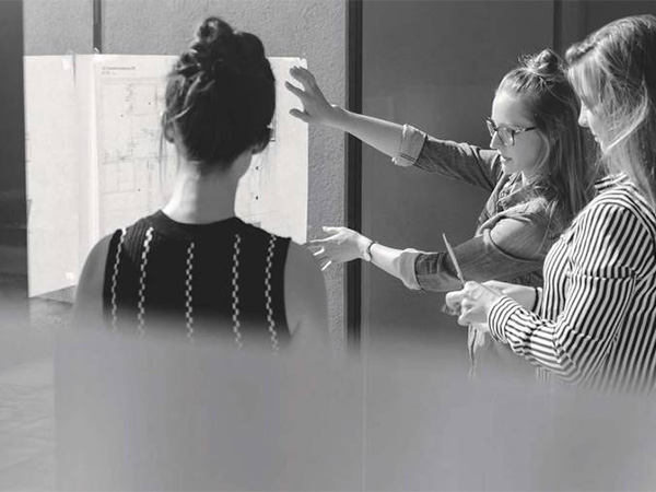 People looking at writings on a whiteboard.