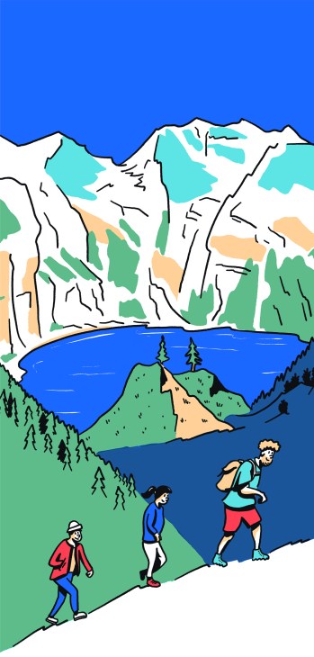 Hikers walking up a hill with a mountain range in the background.
