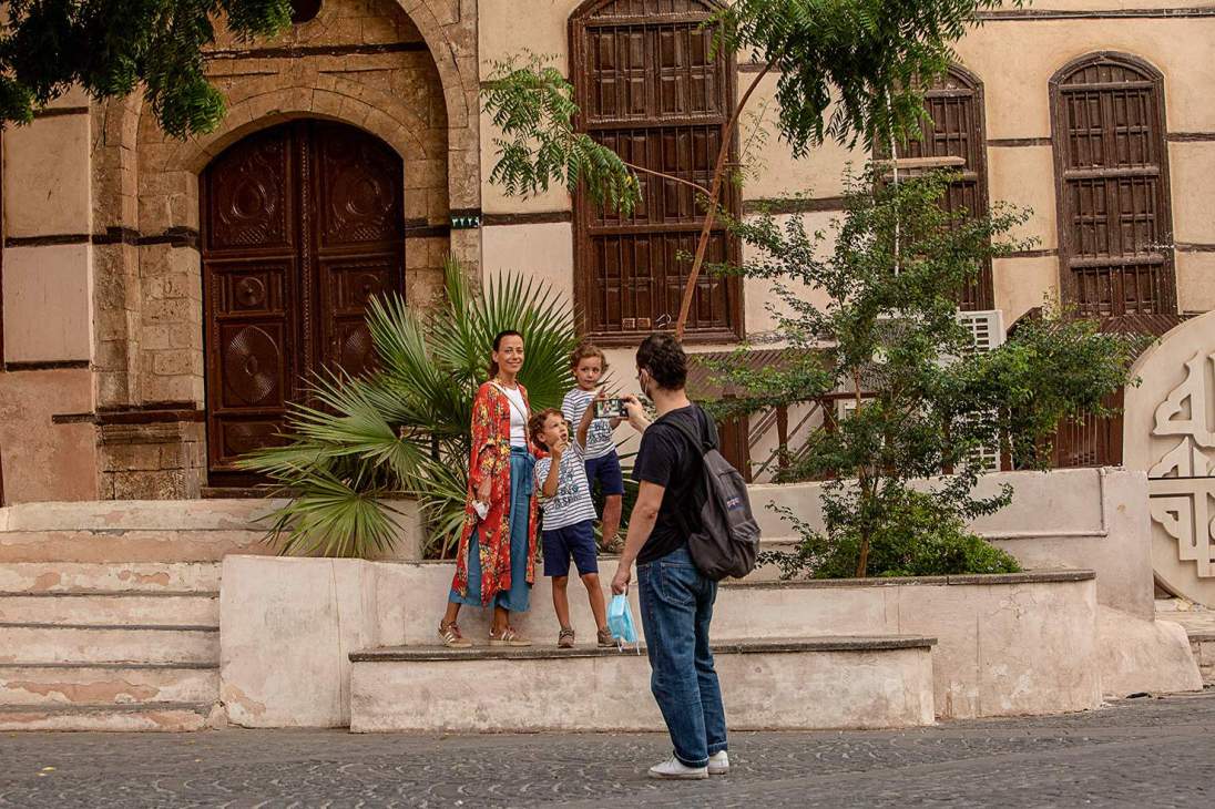 A family posing in front of a building in the old town, in Jeddah.