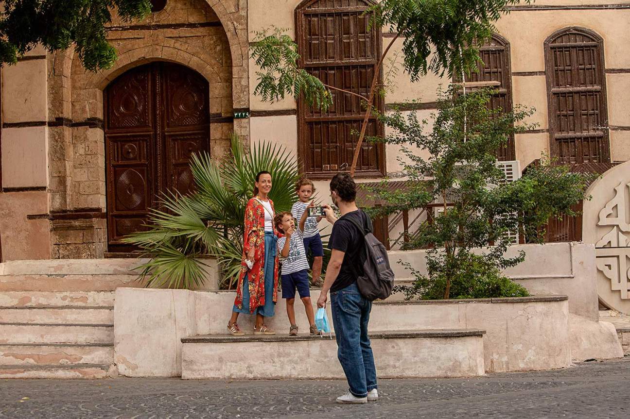 A family posing in front of a building in the old town, in Jeddah.