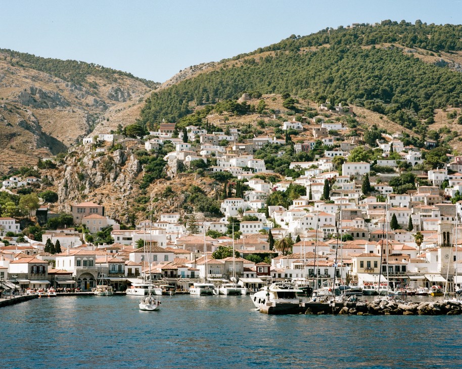 Hydra’s main town with houses on the hillside and boats in the port
