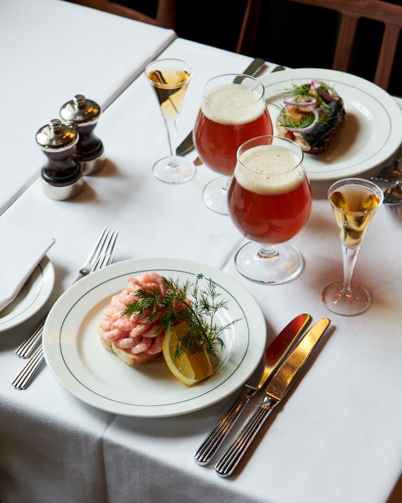 white tablecloth with a meal and glasses of beer and champagne