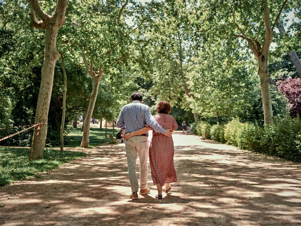 A couple stroll through a park in Madrid