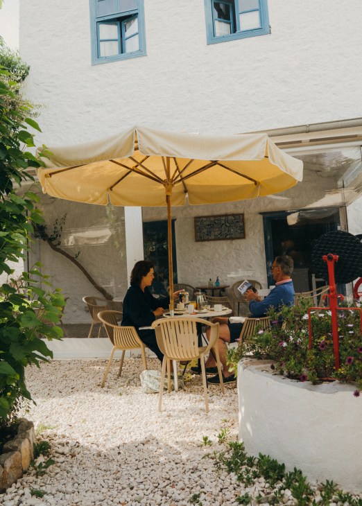 Two people sitting under a sun shade