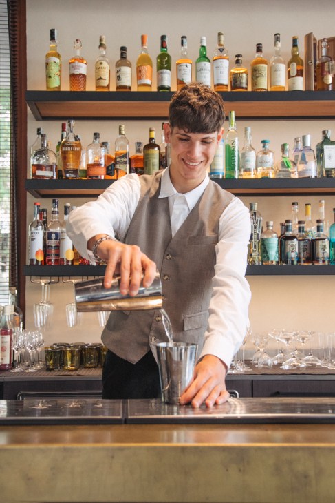 Person preparing a cocktail at the bar