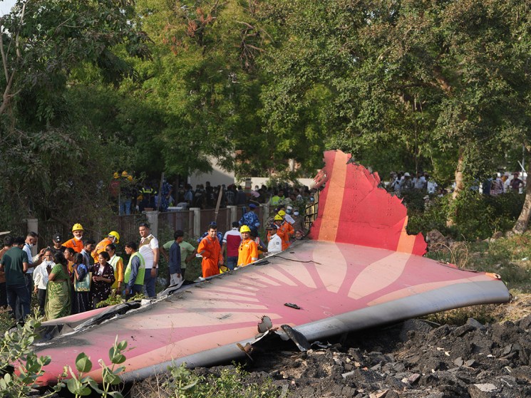 People stand around the debris of an airplane after it crashed in India's northwestern city of Ahmedabad in Gujarat state, Thursday, June 12, 2025. (AP Photo/Ajit Solanki)
