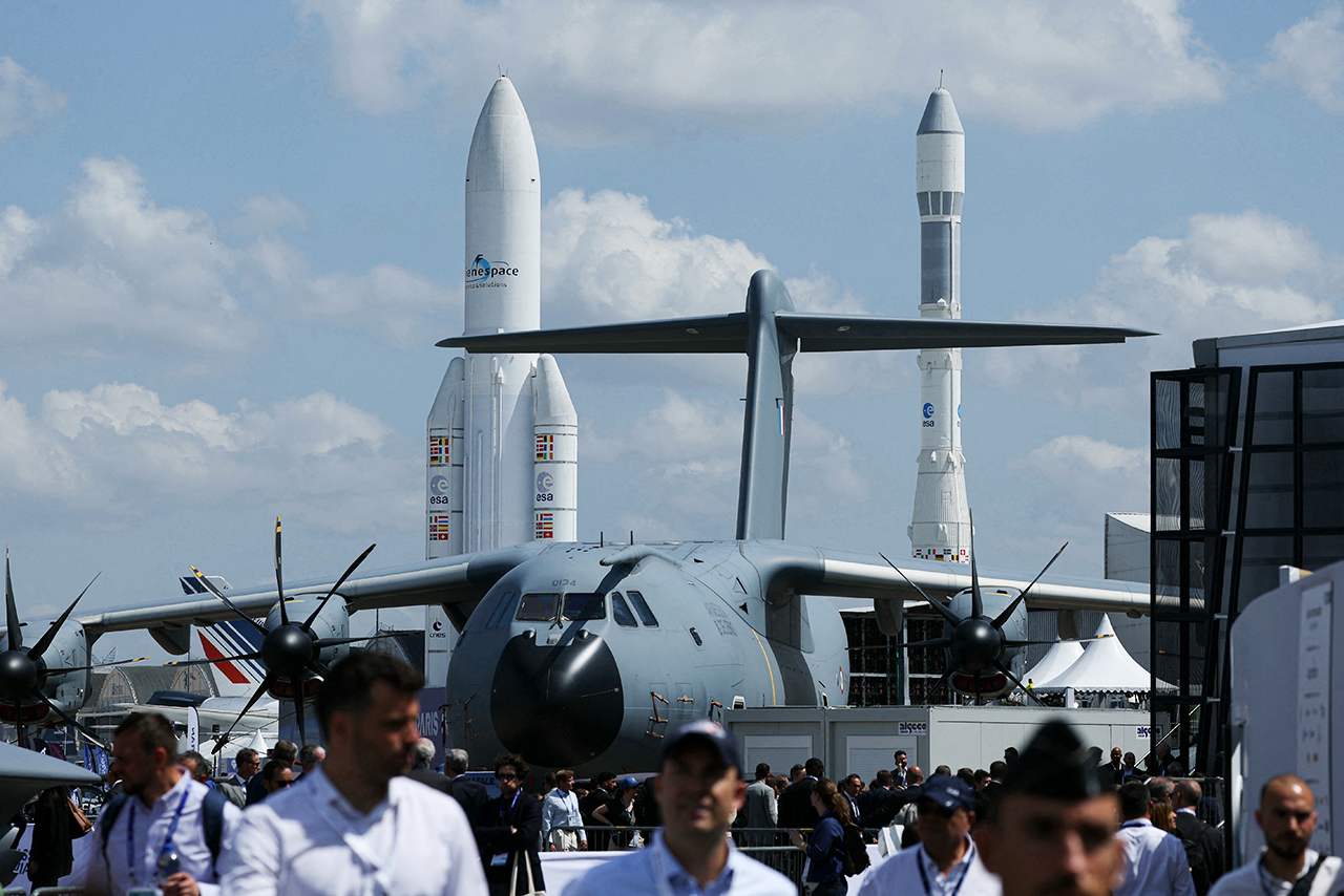 Airbus A400M Grizzly - 0134 military aircraft with aircrafts and Ariane 1 (R) and Ariane 5 ECA space rockets displayed in the background during the 55th edition of the International Paris Air Show at the ParisLe Bourget Airport