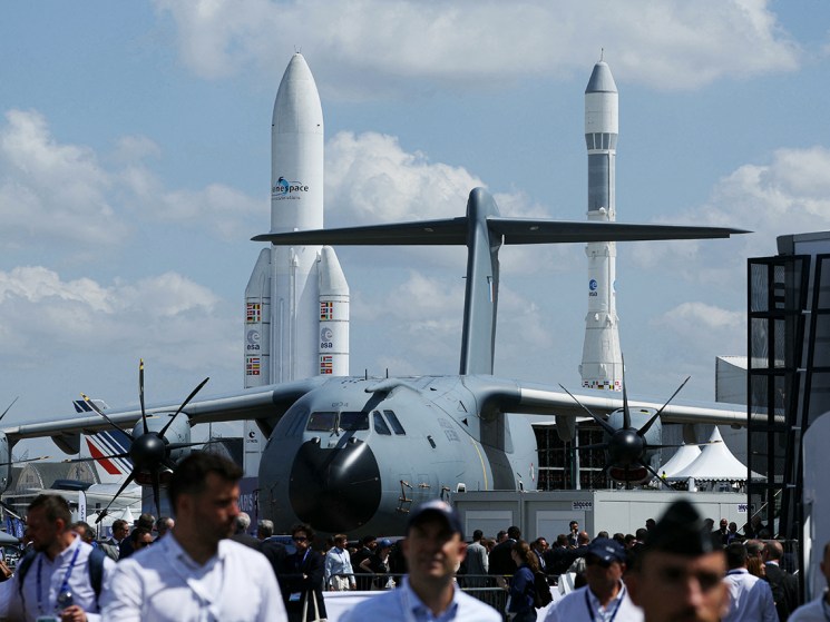 Airbus A400M Grizzly - 0134 military aircraft with aircrafts and Ariane 1 (R) and Ariane 5 ECA space rockets displayed in the background during the 55th edition of the International Paris Air Show at the ParisLe Bourget Airport