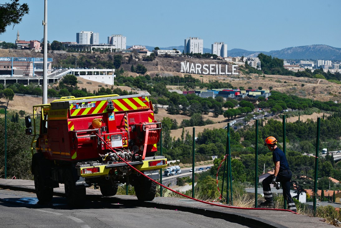 A firefighter inspects a scorched area on Marseille's outskirts