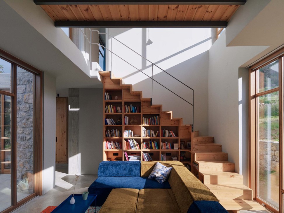 Inside the house with wooden staircase and shelving with books