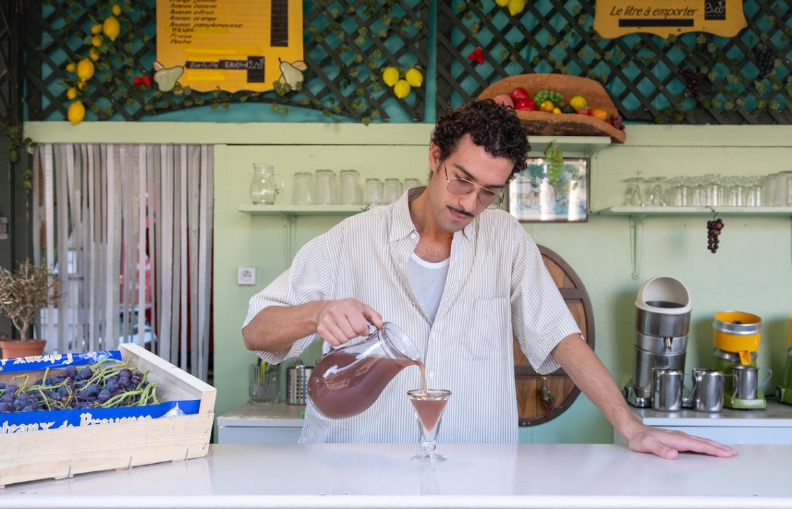Yannis Amarkaze, owner of Station Uvale du Palais serves fresh pressed juice made from Cardinal grapes at his kiosk. Friday, Aug. 25, 2023. Marseille, France, ©Annie Etheridge