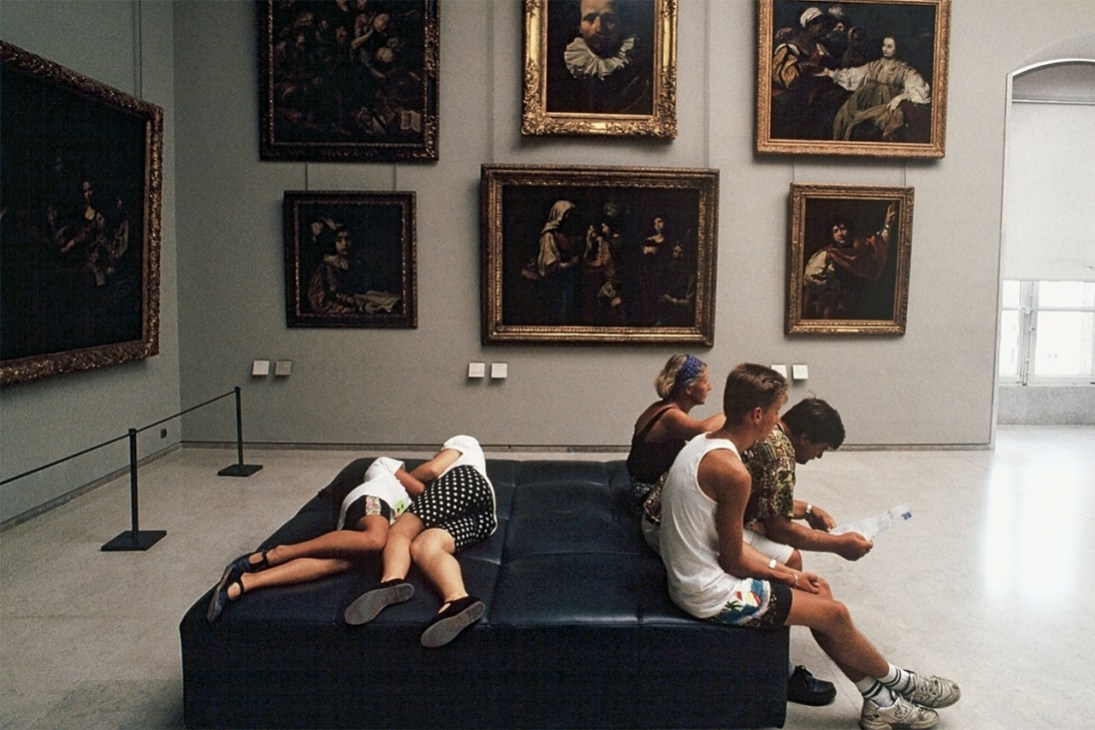 People sitting and lying down in an art gallery.