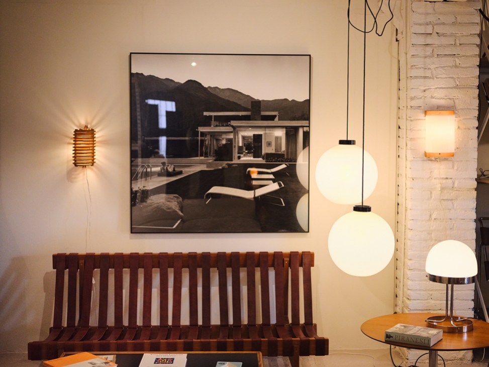 Rationalist walnut sofa
with leather straps from
the 1960s, alongside
two 1965 globe pendant
lamps by Miguel Milá
for Polinax