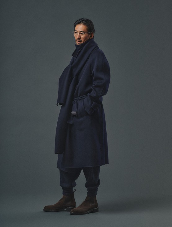 Male model in coat, rollneck jumper,
trousers, socks and boots by Loro
Piana, glasses by Lindberg