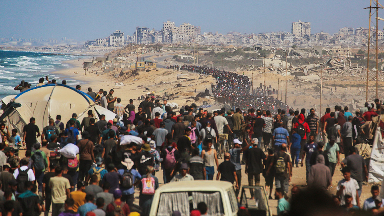 Palestinians walk along Al-Rashid road toward Gaza City from Nuseirat in the central Gaza Strip