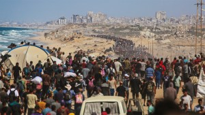 Palestinians walk along Al-Rashid road toward Gaza City from Nuseirat in the central Gaza Strip