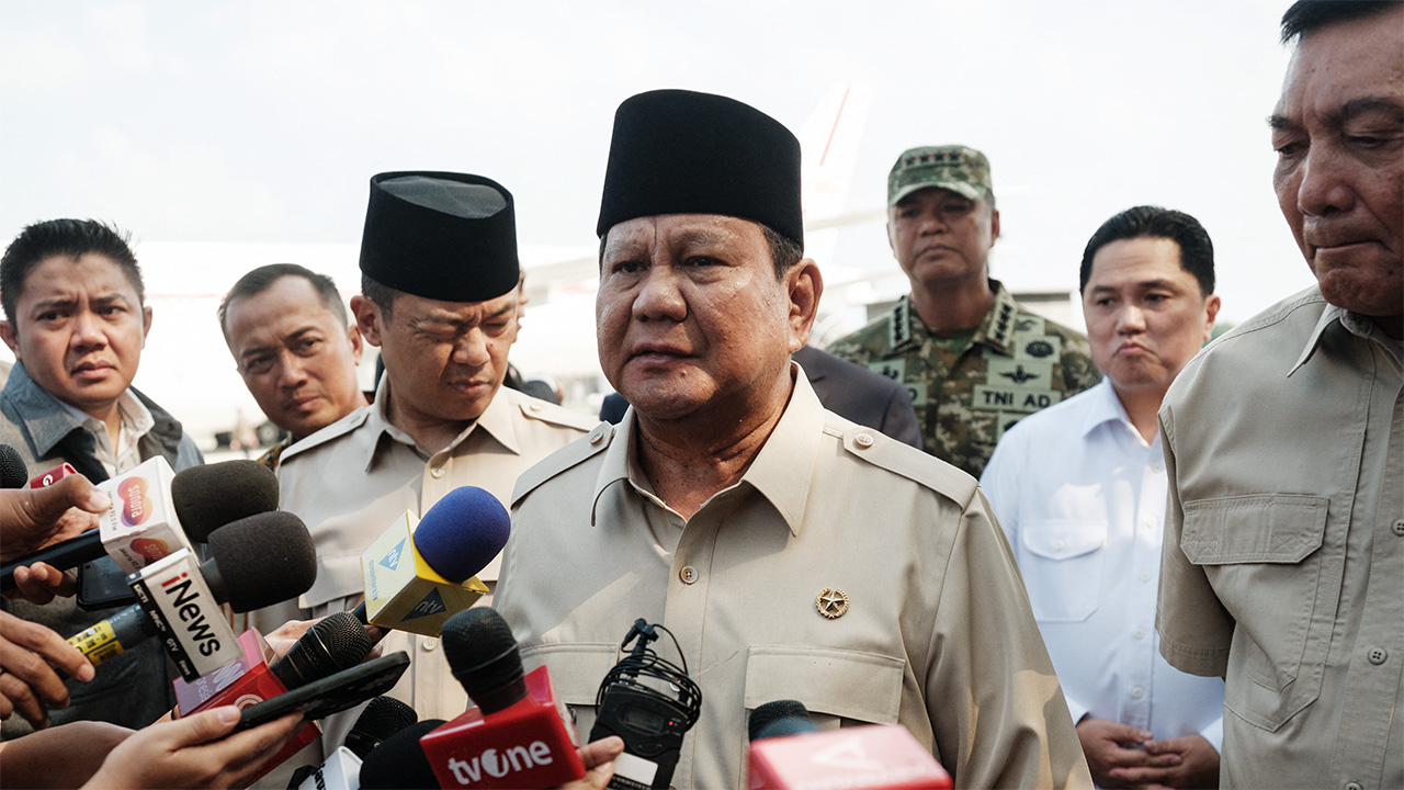 Indonesia's President Prabowo Subianto (C) speaks to media upon arrival from Egypt after attending the Gaza peace summit at Halim Perdanakusuma Air Force Base in Jakarta,