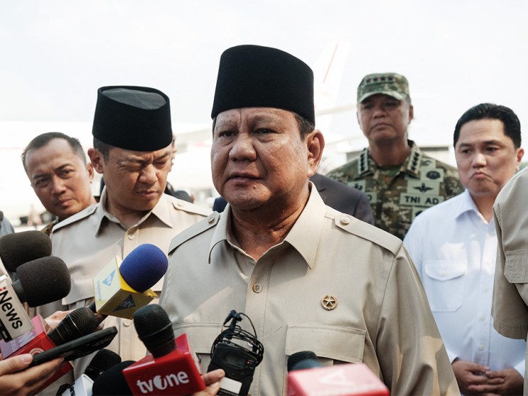 Indonesia's President Prabowo Subianto (C) speaks to media upon arrival from Egypt after attending the Gaza peace summit at Halim Perdanakusuma Air Force Base in Jakarta,