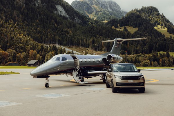 A Range Rover and jet parked on a runway