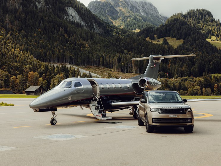 A Range Rover and jet parked on a runway