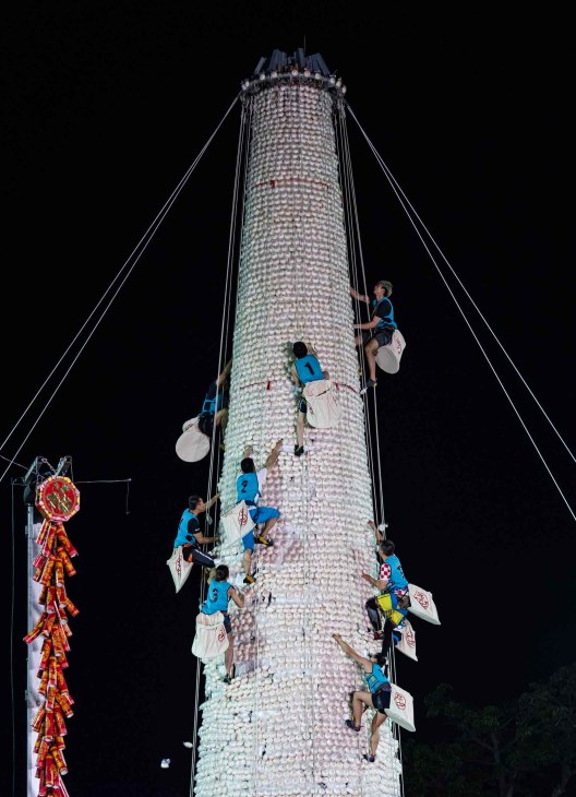 Participants climb the bun tower to snatch as many buns as they can during the Bun Scrambling Competition in Cheung Chau Island on May 6, 2025 in Hong Kong, China.