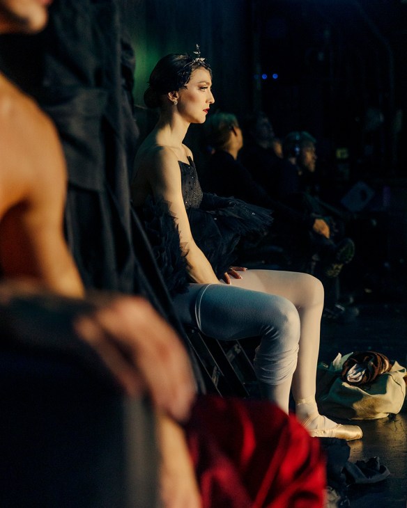 Lead dancer of Swan Lake sits backstage looking pensive
