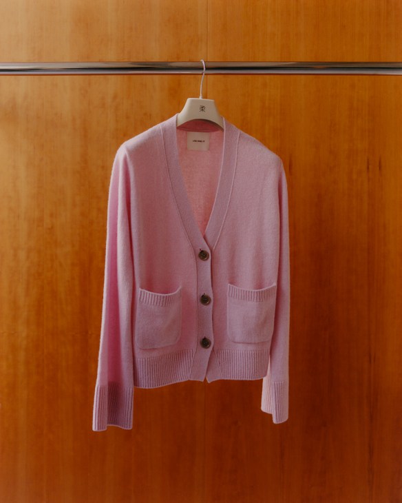 Lisa Yang cardigan in soft pink hangs on rail 