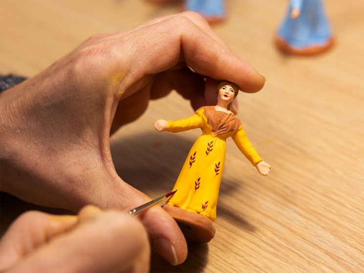 A female santon in a yellow dress made santons at Ateliers Marcel Carbone