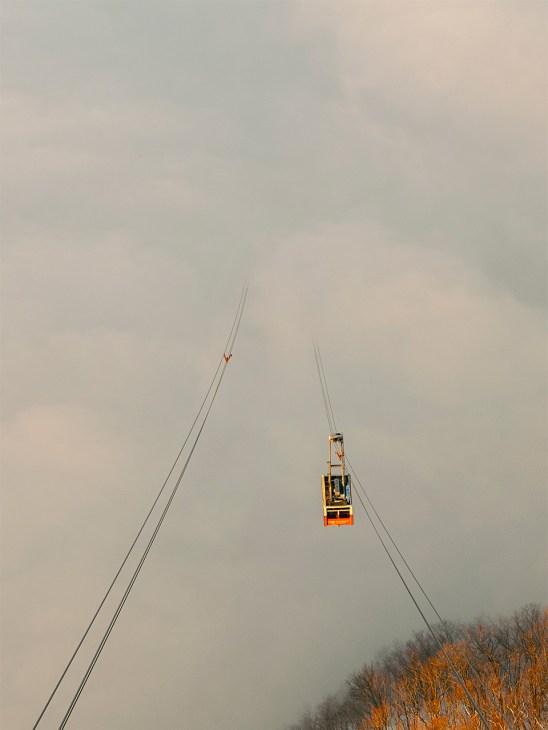 cable car descends from within the clouds