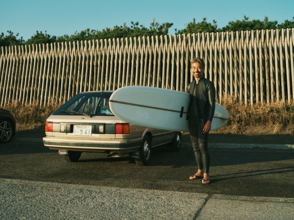 A surfer smiles at the camera in Aoshima