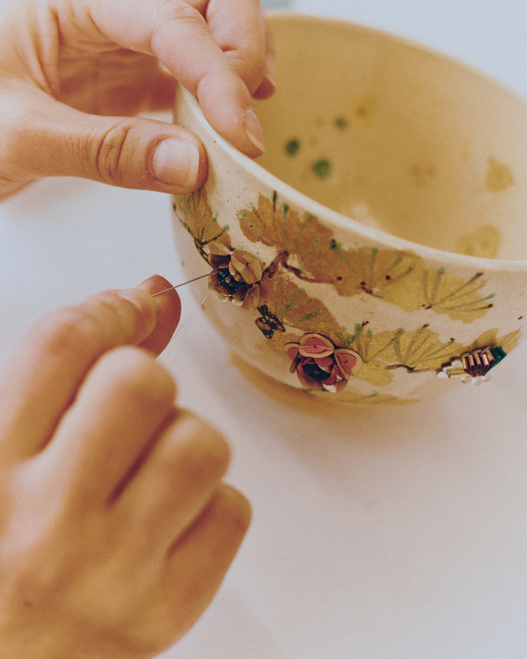 Beads and sequins are hand-stitched onto ceramics