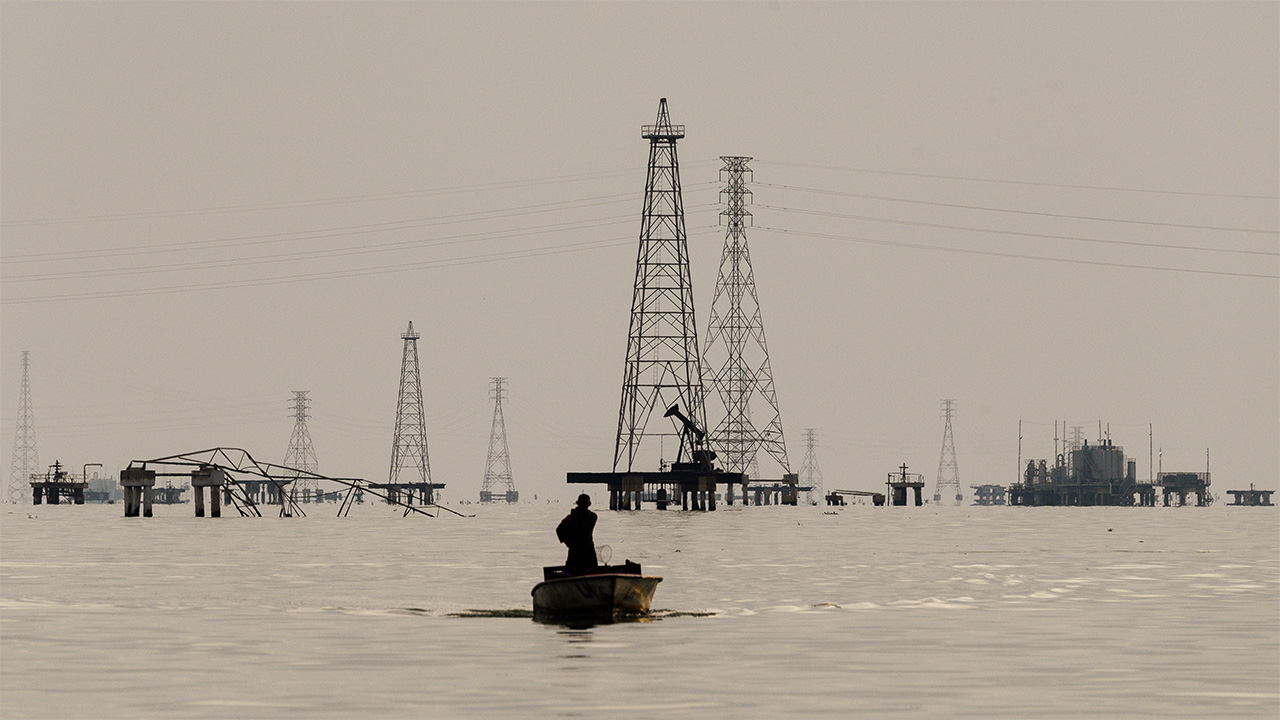 Fishermen in front of Petroleos de Venezuela SA (PDVSA) oil rigs on Lake Maracaibo in Cabimas, Zulia state, Venezuela
