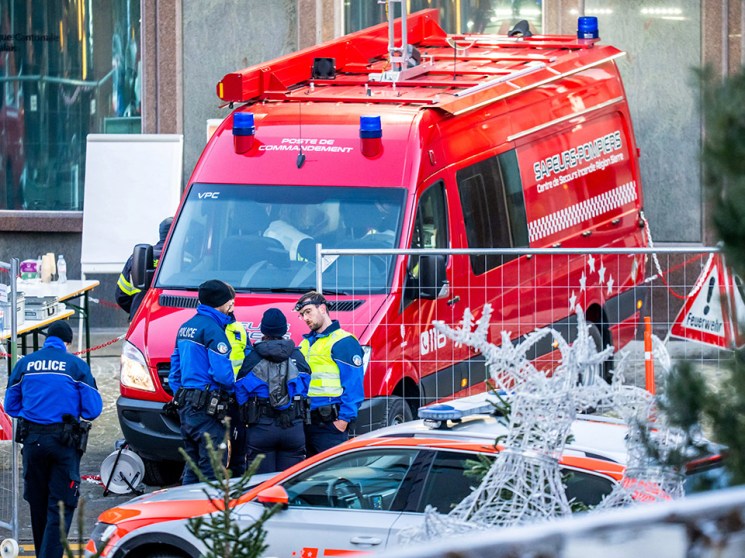 Police officers and rescuers stand next to a firefighters vehicle on the site of a fire that ripped through the bar Le Constellation in Crans-Montana on January 1, 2026. Several dozen people are presumed dead and around 100 injured after a fire ripped through a crowded bar in the luxury Swiss ski resort of Crans-Montana, Swiss police said on January 1, 2026. Police, firefighters and rescuers rushed to the popular resort, which is set to host the Ski World Cup from January 30, after the fire broke out in the early hours of New Year's Day. (Photo by MAXIME SCHMID / AFP via Getty Images)
