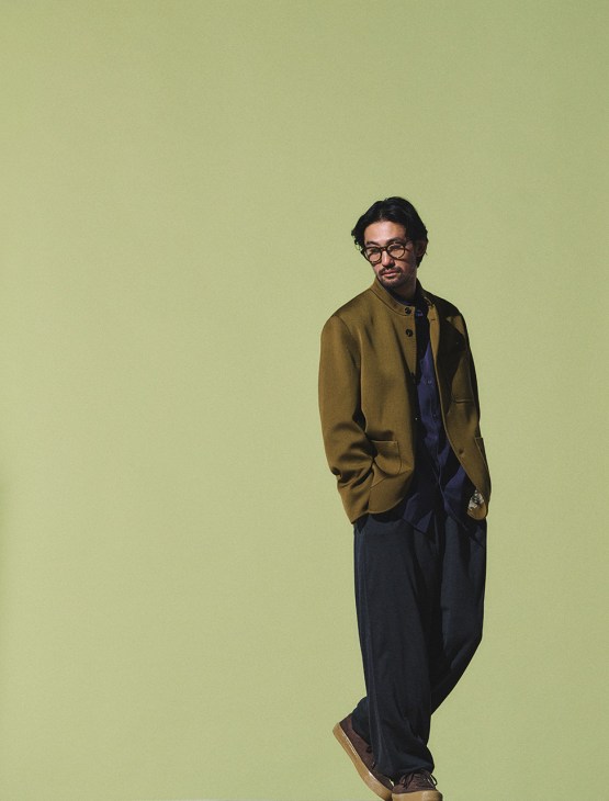 Model wearing jacket and shirt by Berluti, trousers by Comoli, trainers by Last Resort AB, glasses by Mykita