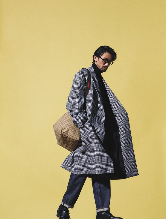 Model wearing coat, rollneck jumper and bag by Gucci, jeans by Anatomica, shoes by John Lobb, glasses by Mykita