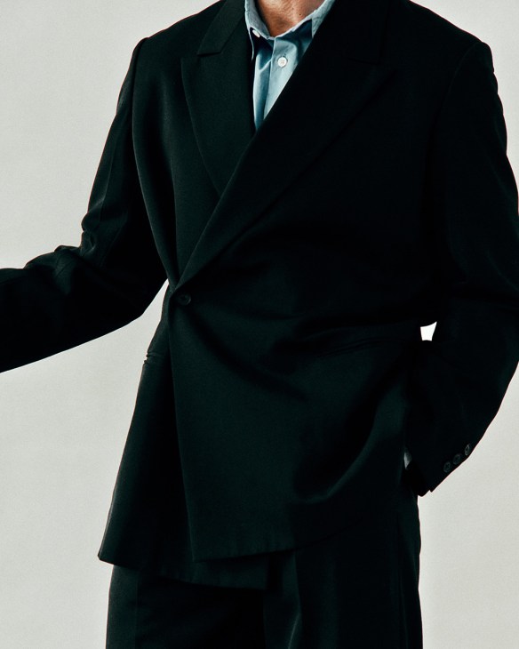 Model wearing black Yoke suit with pale blue shirt