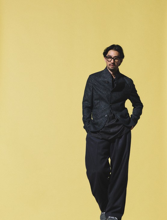 Model wearing Jacket and trousers by Emporio Armani, shirt by Comoli, trainers by Adidas Originals, glasses by Mykita