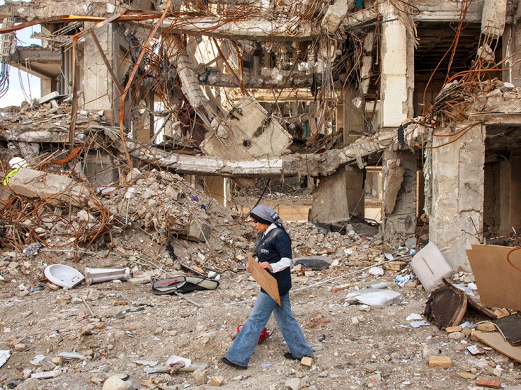 A woman walks among buildings destroyed in a joint attack by Israel and the United States on April 6, 2026, in Tehran, Iran. The United States and Israel continue their joint attack on Iran that began on February 28.