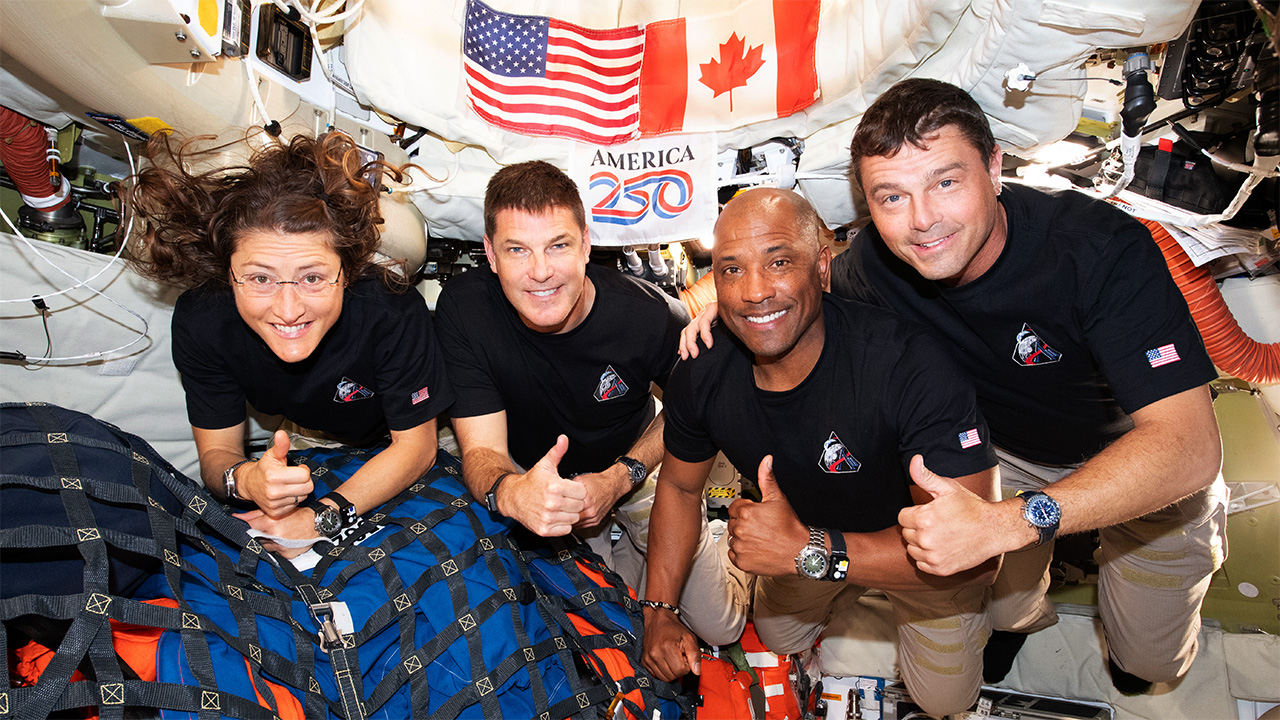 Mission Specialist Christina Koch, Mission Specialist Jeremy Hansen, Pilot Victor Glover, and Commander Reid Wiseman – pause for a group photo inside the Orion spacecraft on their way home. Following a swing around the far side of the Moon on April 6, 2026, the crew exited the lunar sphere of influence
