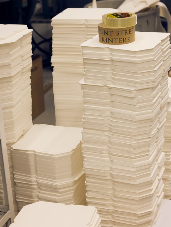 Stacks of white cut paper with Mount Street Printers branded tape on top stack.